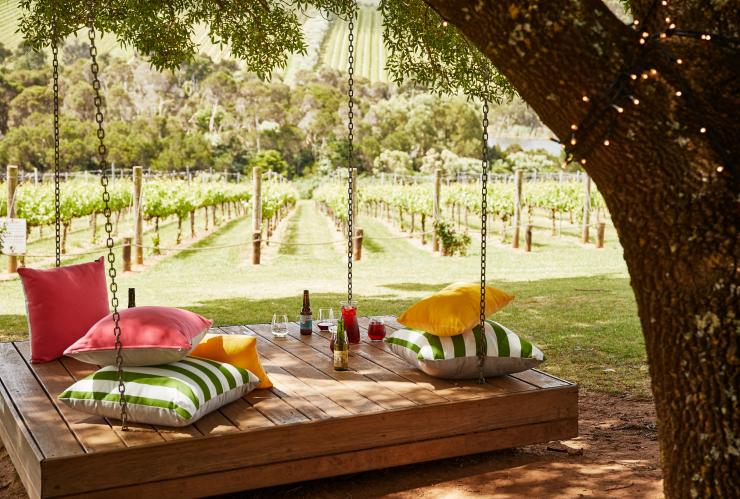 Pillows and drinks on a large wooden swing at Tucks Wine © Griffin Simm Pillows and drinks on a large wooden swing at Tucks Wine © Griffin Simm