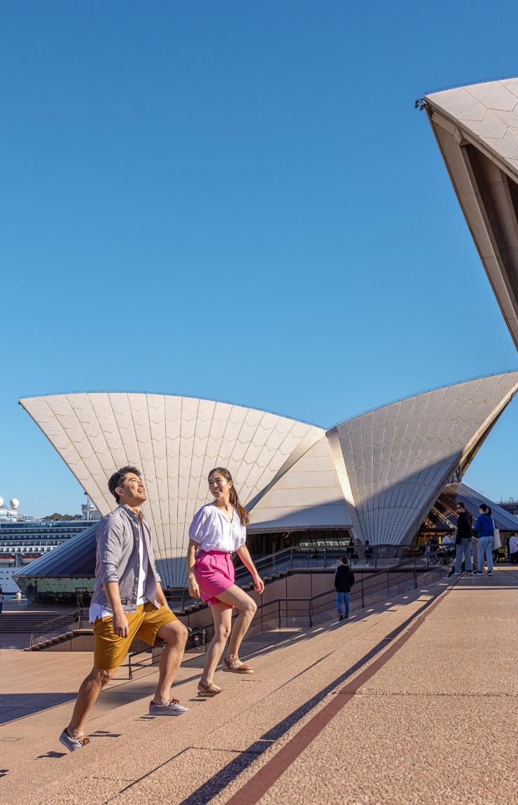 A couple walking along the forecourt in front of the Sydney Opera House, Sydney, New South Wales © Tourism Australia A couple walking along the forecourt in front of the Sydney Opera House, Sydney, New South Wales © Tourism Australia