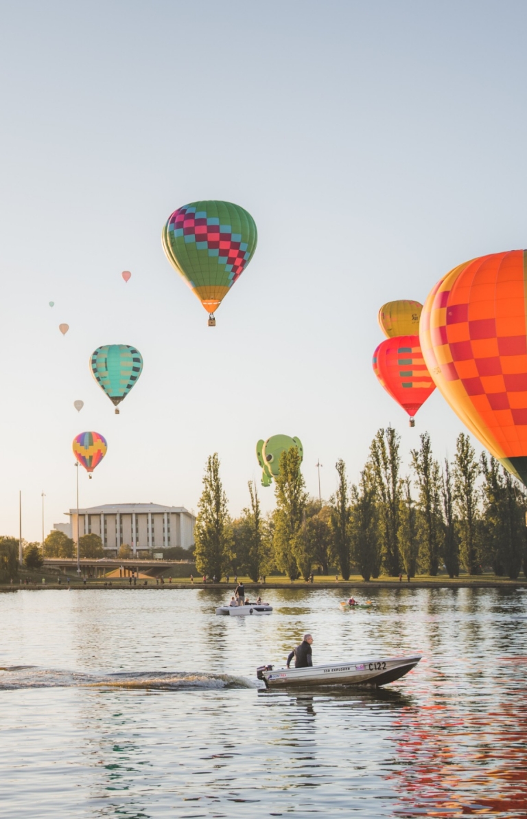 Hot air balloons drifting over the tranquil water of Lake Burley Griffin sprinkled with boats in Canberra, Australian Capital Territory © EventsACT Hot air balloons drifting over the tranquil water of Lake Burley Griffin sprinkled with boats in Canberra, Australian Capital Territory © EventsACT