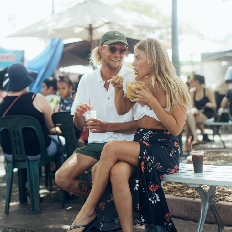 A couple eating Street food at Parap Village Markets, Darwin Northern Territory, outdoors on a sunny day. © Tourism Northern Territory A couple eating Street food at Parap Village Markets, Darwin Northern Territory, outdoors on a sunny day. © Tourism Northern Territory