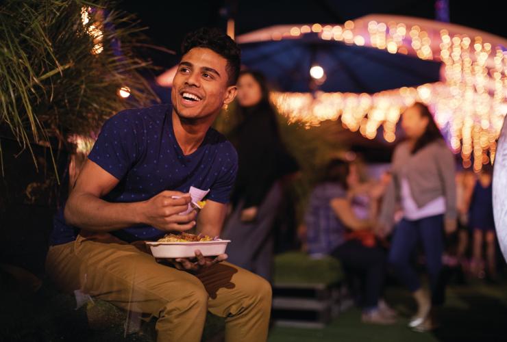 Man eating food at Eat Street Markets in Brisbane © Tourism and Events Queensland Man eating food at Eat Street Markets in Brisbane © Tourism and Events Queensland