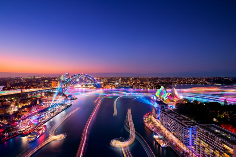Aerial view over a harbour city adorned in rainbow lights during Vivid Sydney, Sydney, New South Wales © Destination NSW Aerial view over a harbour city adorned in rainbow lights during Vivid Sydney, Sydney, New South Wales © Destination NSW