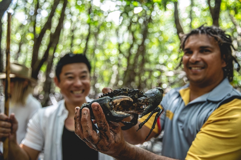 An Indigenous guide holding up a mud crab as a tour participant smiles behind him, Walkabout Cultural Adventures, Daintree Rainforest, Queensland © Tourism and Events Queensland An Indigenous guide holding up a mud crab as a tour participant smiles behind him, Walkabout Cultural Adventures, Daintree Rainforest, Queensland © Tourism and Events Queensland