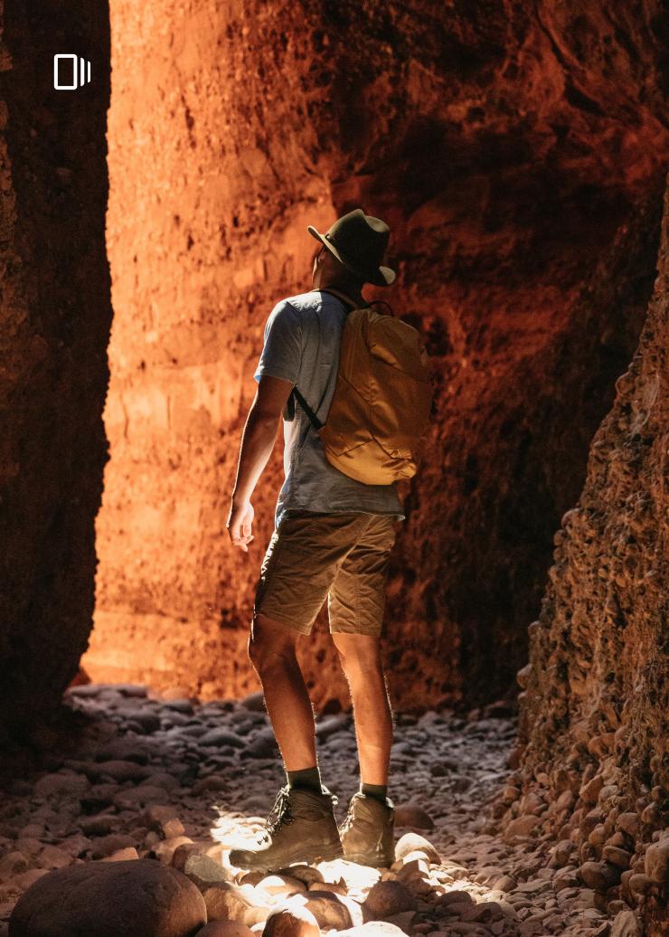 A man faces the red rock walls of Echidna Chasm in the Bungle Bungle Ranges, Western Australia © Tourism Australia A man faces the red rock walls of Echidna Chasm in the Bungle Bungle Ranges, Western Australia © Tourism Australia