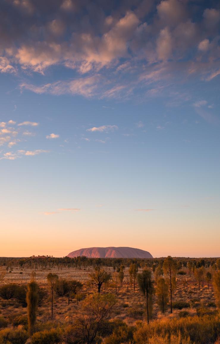 A large red rock monolith rising from the flat outback landscape at Uluru, Uluru-Kata Tjuta National Park, Northern Territory © Tourism Australia A large red rock monolith rising from the flat outback landscape at Uluru, Uluru-Kata Tjuta National Park, Northern Territory © Tourism Australia