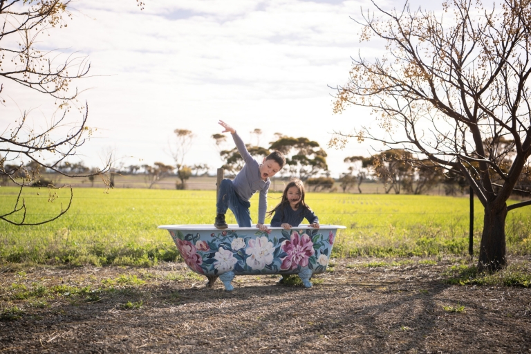 A young boy and girl play in an outdoor bathtub painted with flowers at Redwing Farm, Yorke Peninsula, South Australia © Tourism Australia A young boy and girl play in an outdoor bathtub painted with flowers at Redwing Farm, Yorke Peninsula, South Australia © Tourism Australia