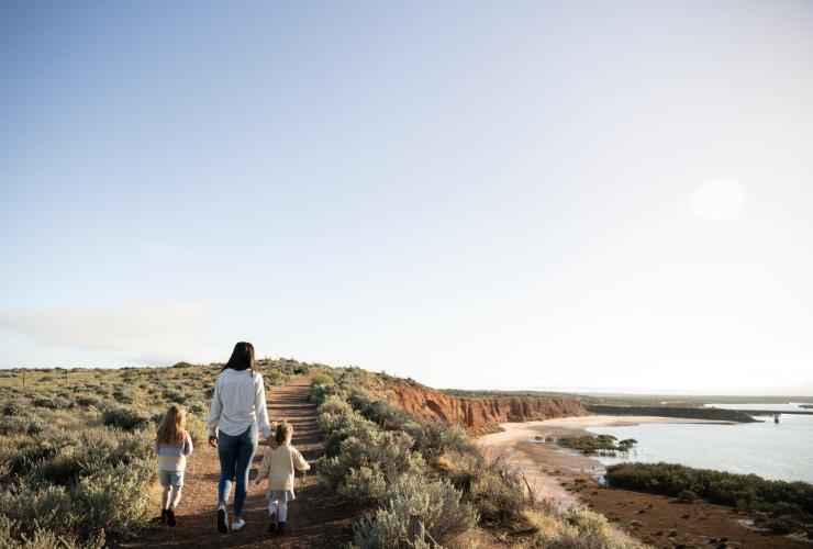 A woman and two children walking on a path bordered by bushland along a headland overlooking a calm blue waterway at Australian Arid Lands Botanic Garden, Port Augusta, South Australia © Tourism Australia / South Australian Tourism Commission A woman and two children walking on a path bordered by bushland along a headland overlooking a calm blue waterway at Australian Arid Lands Botanic Garden, Port Augusta, South Australia © Tourism Australia / South Australian Tourism Commission