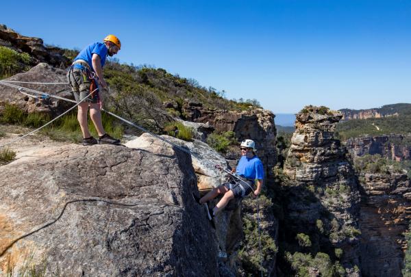 Femme descendant en rappel à Cahills Lookout, Katoomba dans les Blue Mountains © Destination NSW
