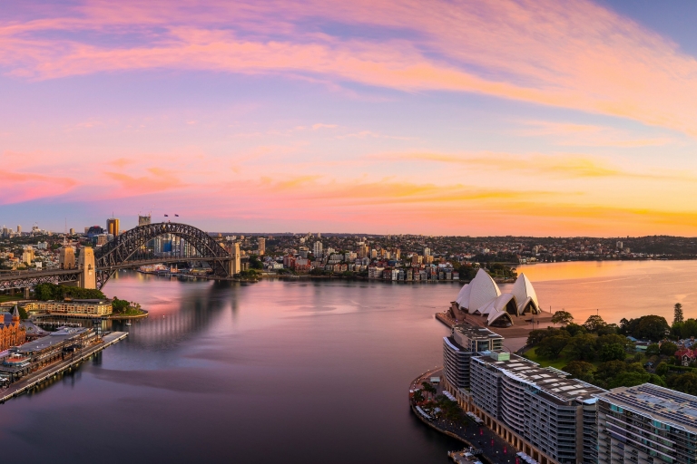 Vue aérienne de la Baie de Sydney réfléchissant les couleurs bleu, rose et doré du coucher au soleil à Sydney, Nouvelle-Galles du Sud © Destination NSW Vue aérienne de la Baie de Sydney réfléchissant les couleurs bleu, rose et doré du coucher au soleil à Sydney, Nouvelle-Galles du Sud © Destination NSW