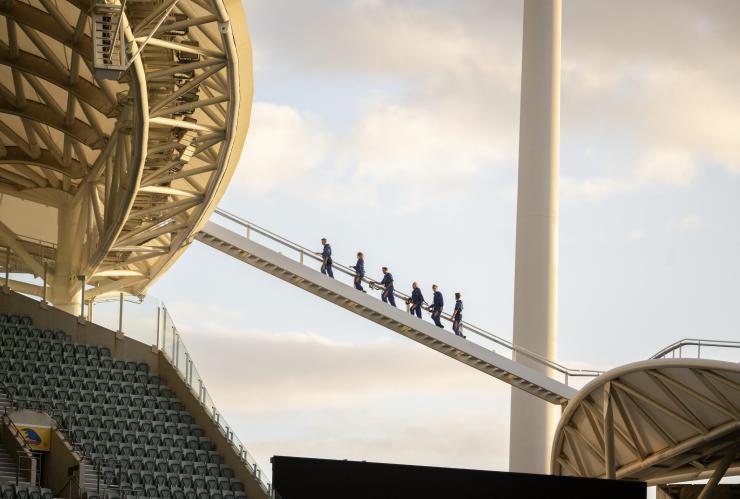 Sekelompok orang berjalan di tangga di atap Adelaide Oval dalam pengalaman RoofClimb, Adelaide, South Australia © Tourism Australia