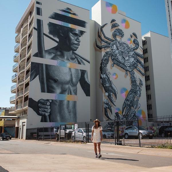 Donna in piedi davanti a un murale a Darwin © Tourism Australia