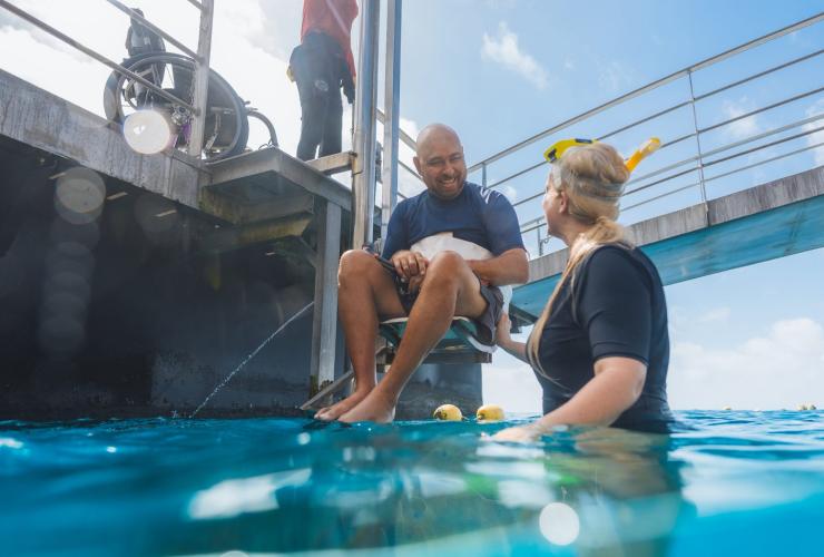 Utente di sedia a rotelle che viene calato nell'oceano con un ascensore con Quicksilver Cruises, Grande Barriera Corallina, Queensland © Tourism and Events Queensland