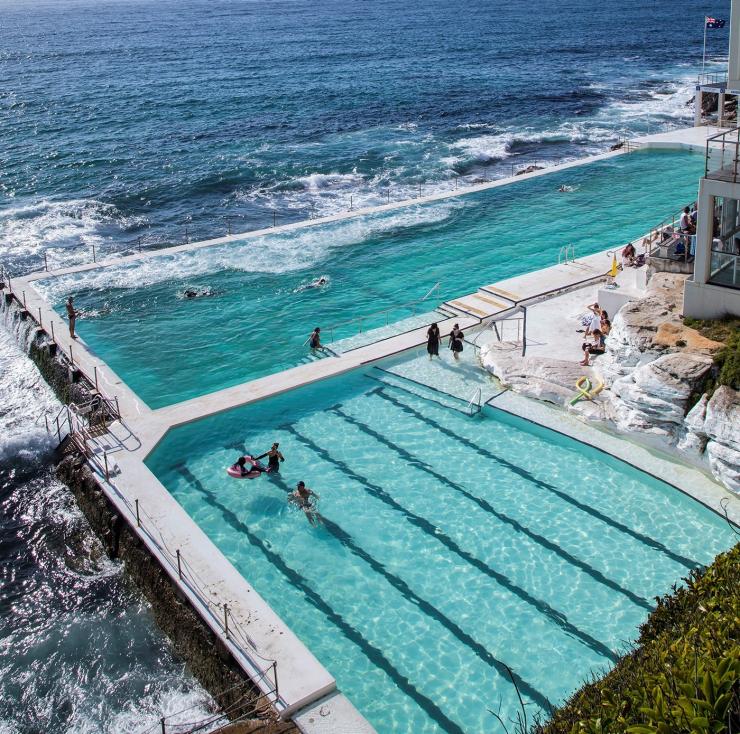 Vista aerea di persone che nuotano nelle acque blu di Bondi Icebergs a Bondi Beach, Sydney, New South Wales © Destination NSW