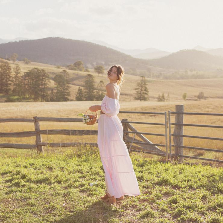 Modella in piedi in un recinto che indossa un abito di The Travelling Kimono, Noosa © Bec Blooms Photography Modella in piedi in un recinto che indossa un abito di The Travelling Kimono, Noosa © Bec Blooms Photography