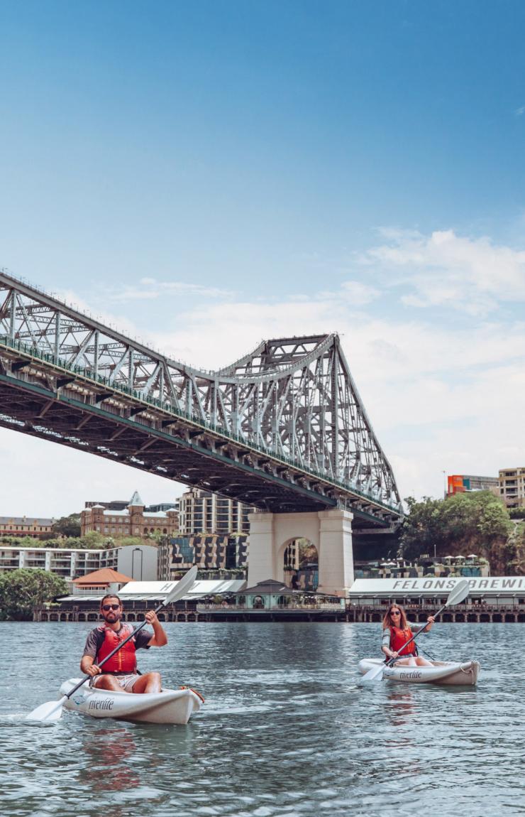 Un uomo e una donna che vanno in kayak con Riverlife sul Brisbane River sotto lo Story Bridge con Howard Smith Wharves sullo sfondo a Brisbane, Queensland © Tourism and Events Queensland Un uomo e una donna che vanno in kayak con Riverlife sul Brisbane River sotto lo Story Bridge con Howard Smith Wharves sullo sfondo a Brisbane, Queensland © Tourism and Events Queensland