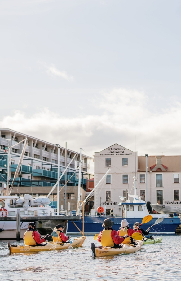 A group of people in yellow kayaks paddle among boats in a marina with Roaring 40s Kayaking  in Hobart, Tasmania © Tourism Australia A group of people in yellow kayaks paddle among boats in a marina with Roaring 40s Kayaking  in Hobart, Tasmania © Tourism Australia