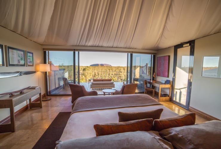 Innenaufnahme der Unterkunft des Longitude 131 in Yulara mit Blick aus dem Fenster auf einen privaten Außenbereich und im Hintergrund der Uluru, Northern Territory © Baillie Lodges