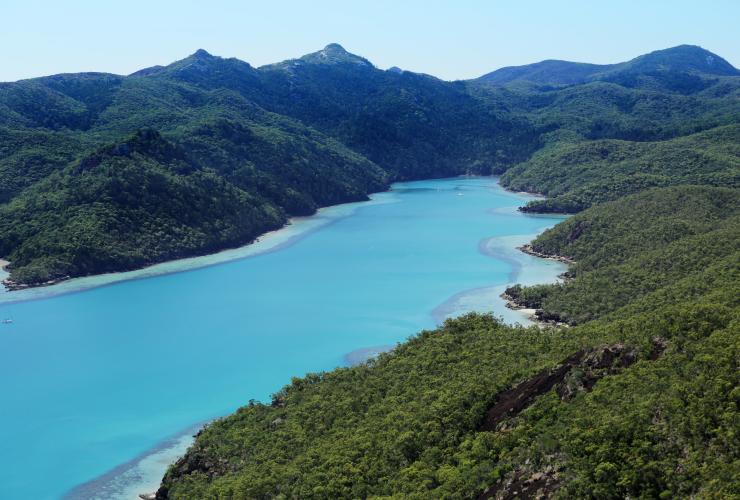 Luftaufnahme des leuchtend blauen Wassers der Nara Inlet, umgeben von der Vegetation von Hamilton Island am qualia, Queensland © qualia