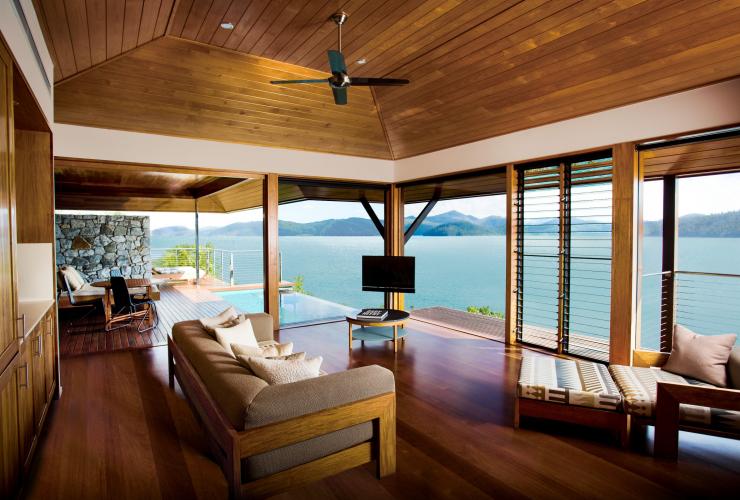 Innenaufnahme der Unterkunft mit Holzboden, einem privaten Pool und bodentiefen Fenstern mit Blick auf den Ozean im qualia, Hamilton Island, Queensland © Hamilton Island